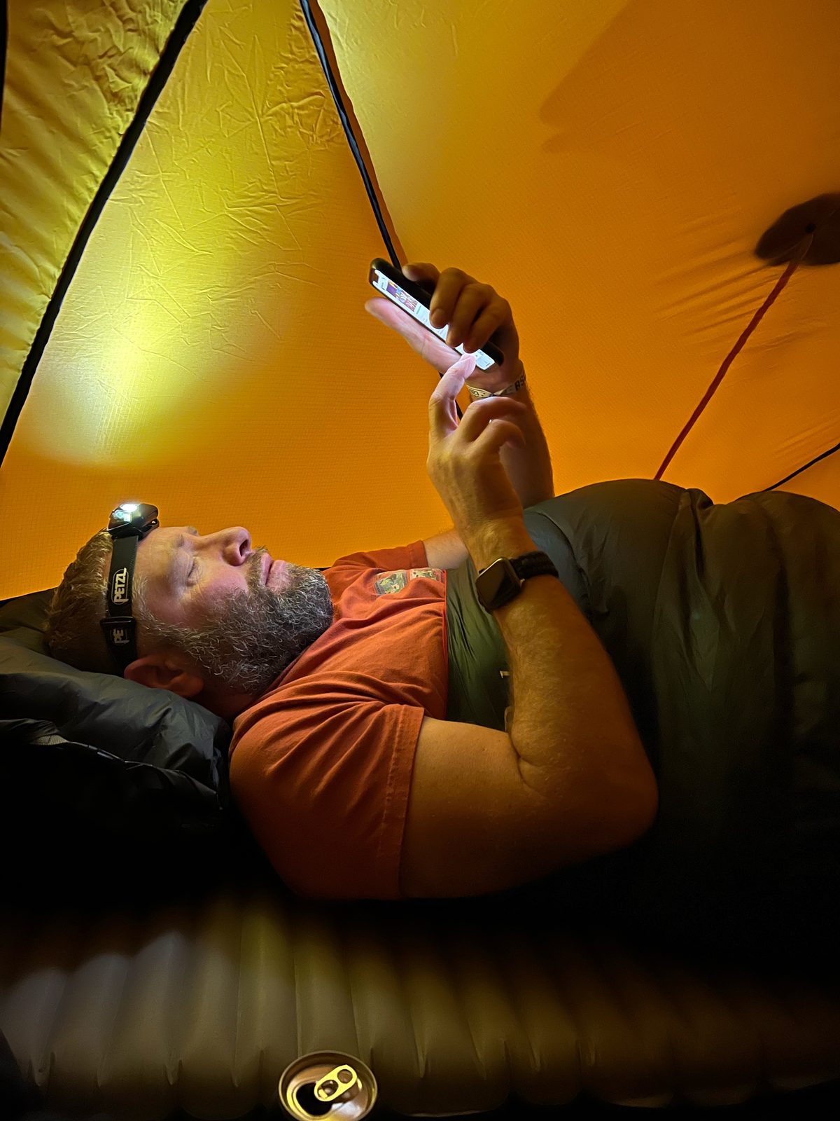 Jason’s tent life: head torch on, phone out, beard doing most of the insulating
