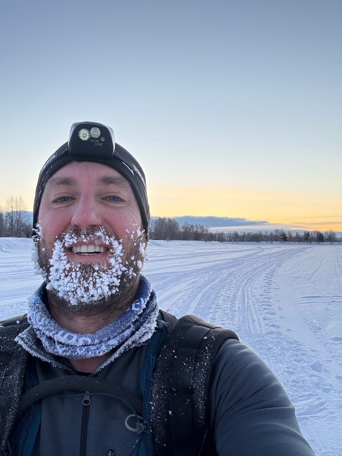 Rob grinning on the Lapland Arctic Ultra 2026, his beard and moustache frozen solid